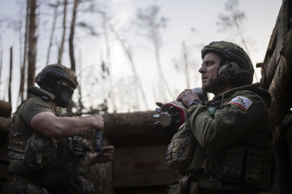 A Ukrainian serviceman holds a mortar shell.