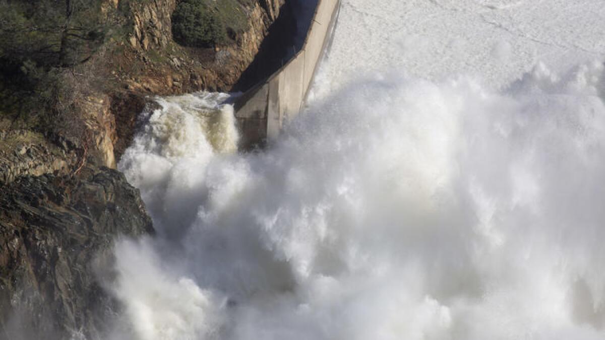 Water from Lake Oroville flows down a damaged main spillway.