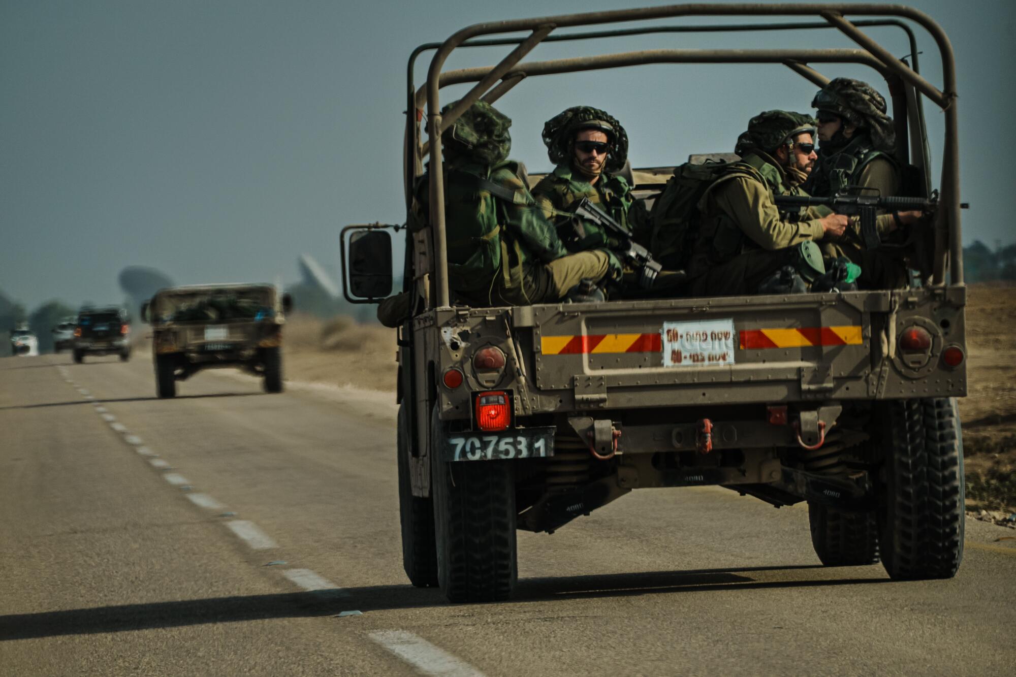 Israeli soldiers ride on a transport vehicle near Re'im, Israel on Tuesday.
