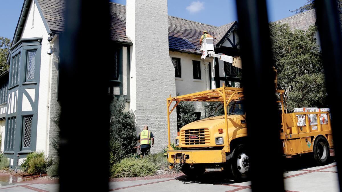 City workers clean the home of Los Angeles Mayor Eric Garcetti after eggs were thrown at it Saturday after the fatal LAPD shooting of an 18-year-old man.