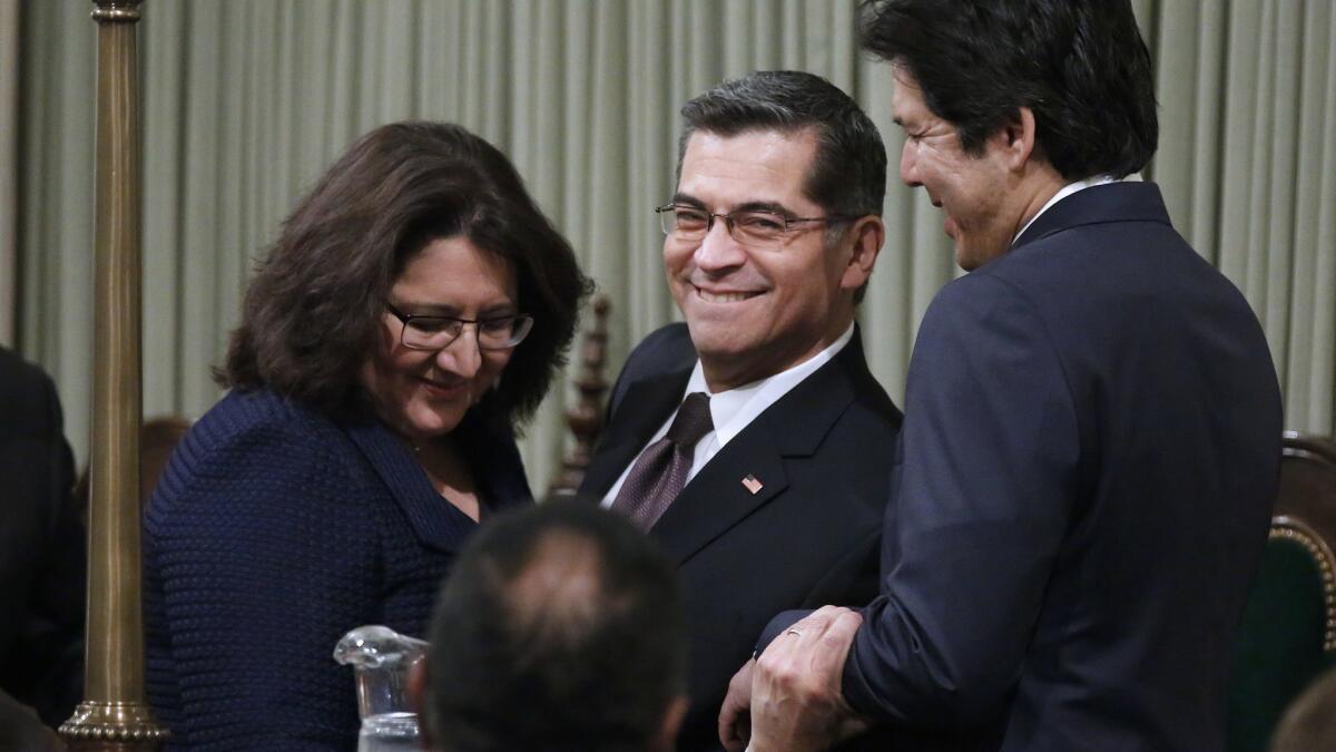 Xavier Becerra, center, and his wife, Carolina Reyes, left, are congratulated by former Senate leader Kevin de León after being sworn in as California's attorney general in 2017.