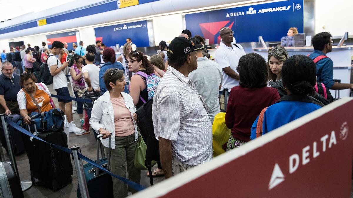 Travelers wait in line at the Delta check-in counter at LaGuardia Airport on Monday.
