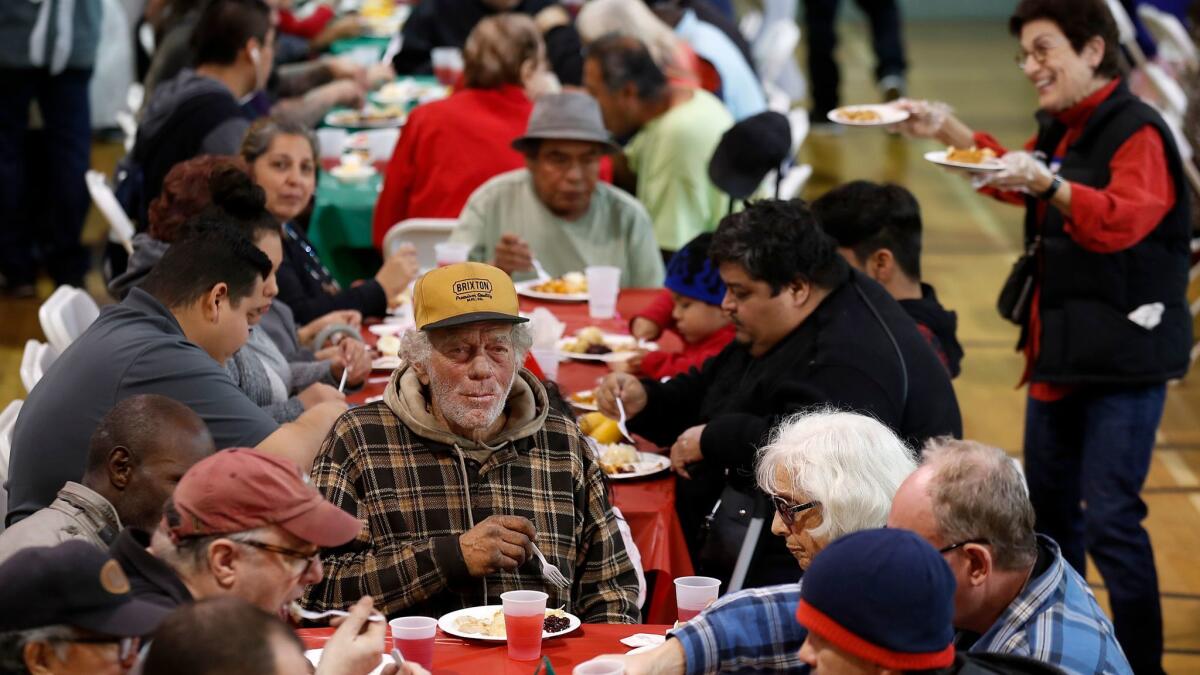 Homeless people and families in need gather at the Hollywood United Methodist Church for a free holiday meal, clothing and toys.