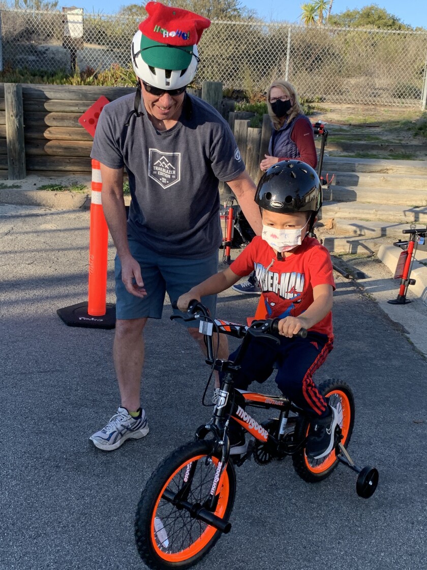 John Page offers encouragement as a student learns to ride his new bike.
