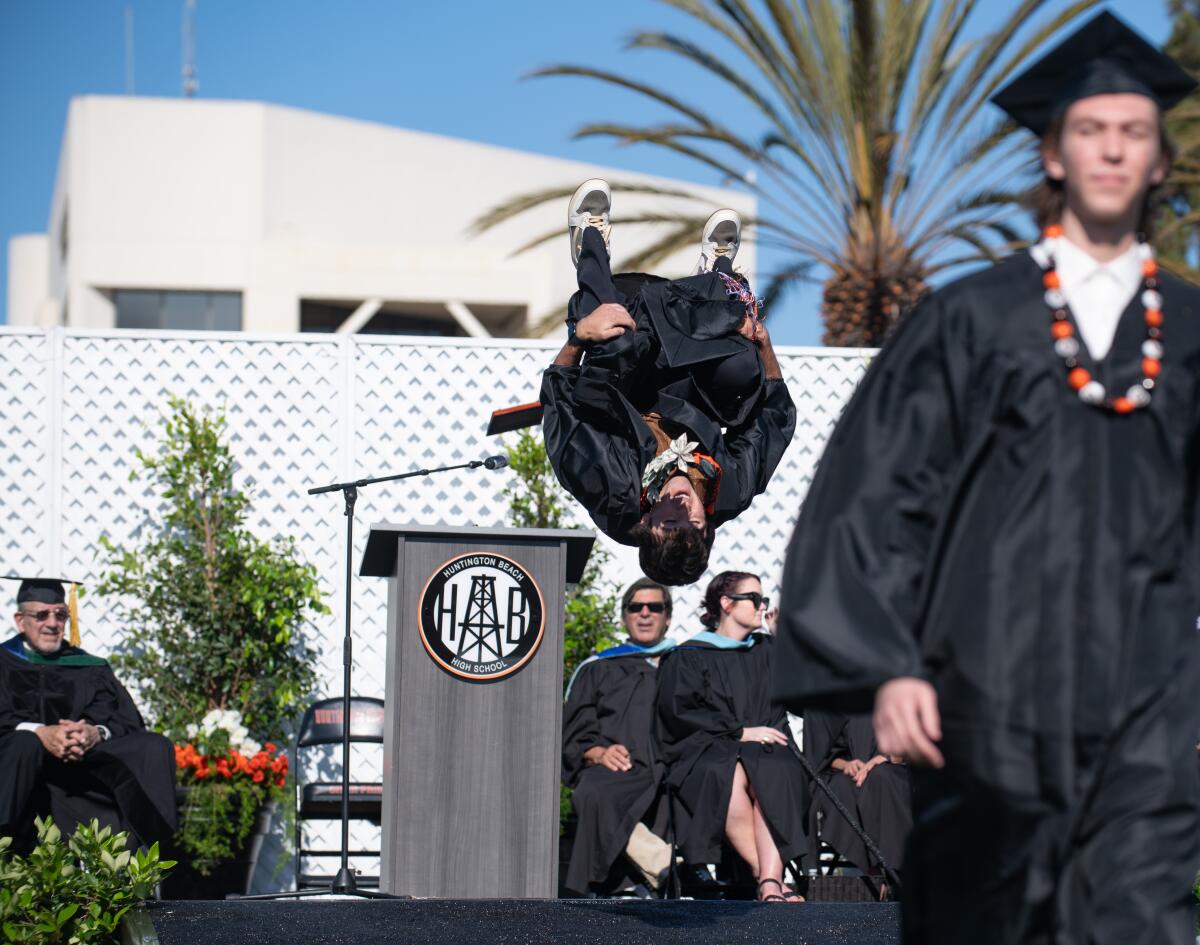 A senior backflips after receiving his diploma from Huntington Beach High on Wednesday.
