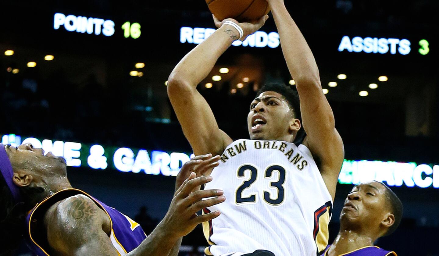 New Orleans forward Anthony Davis shoots over Lakers center Jordan Hill, left, and forward Wesley Johnson, right, during the Pelicans' 96-80 victory over the Lakers on Jan. 21.