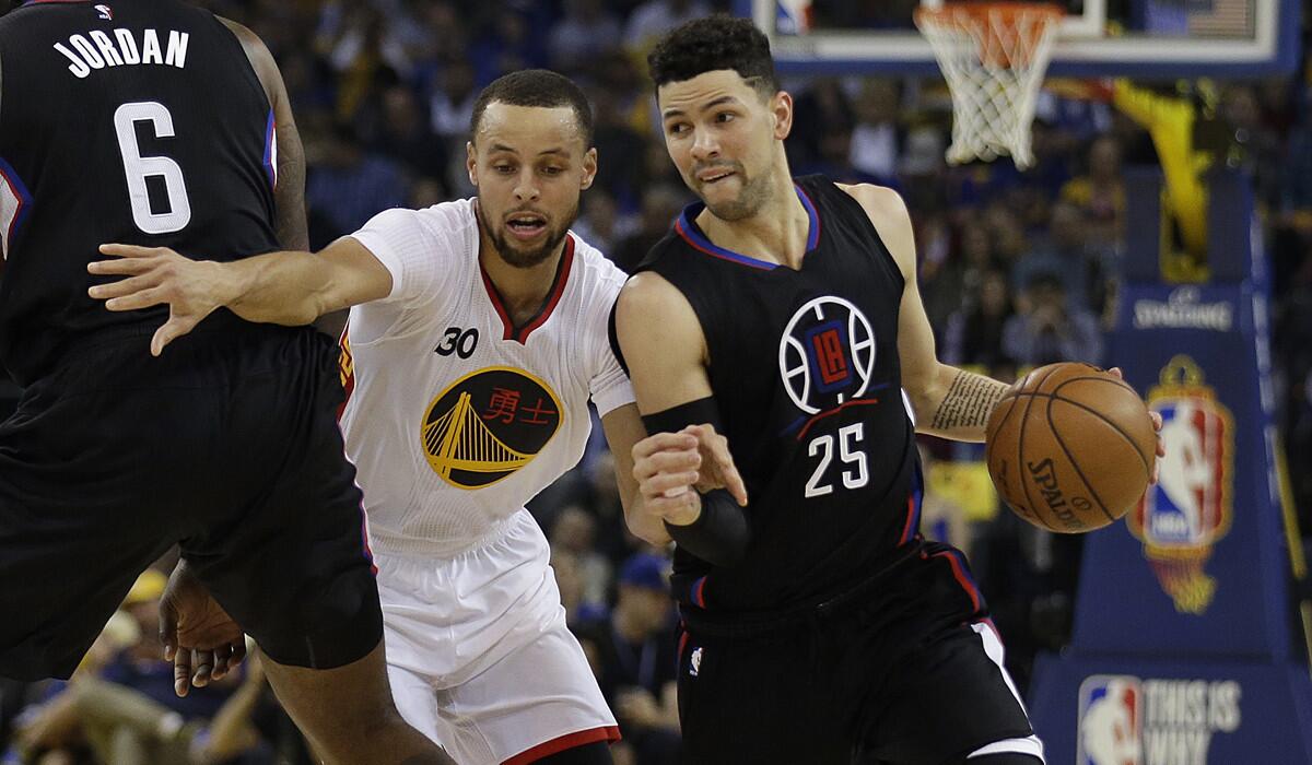 Clippers' Austin Rivers (25) drives the ball as teammate DeAndre Jordan (6) blocks Golden State Warriors' Stephen Curry (30) during the first half Saturday.