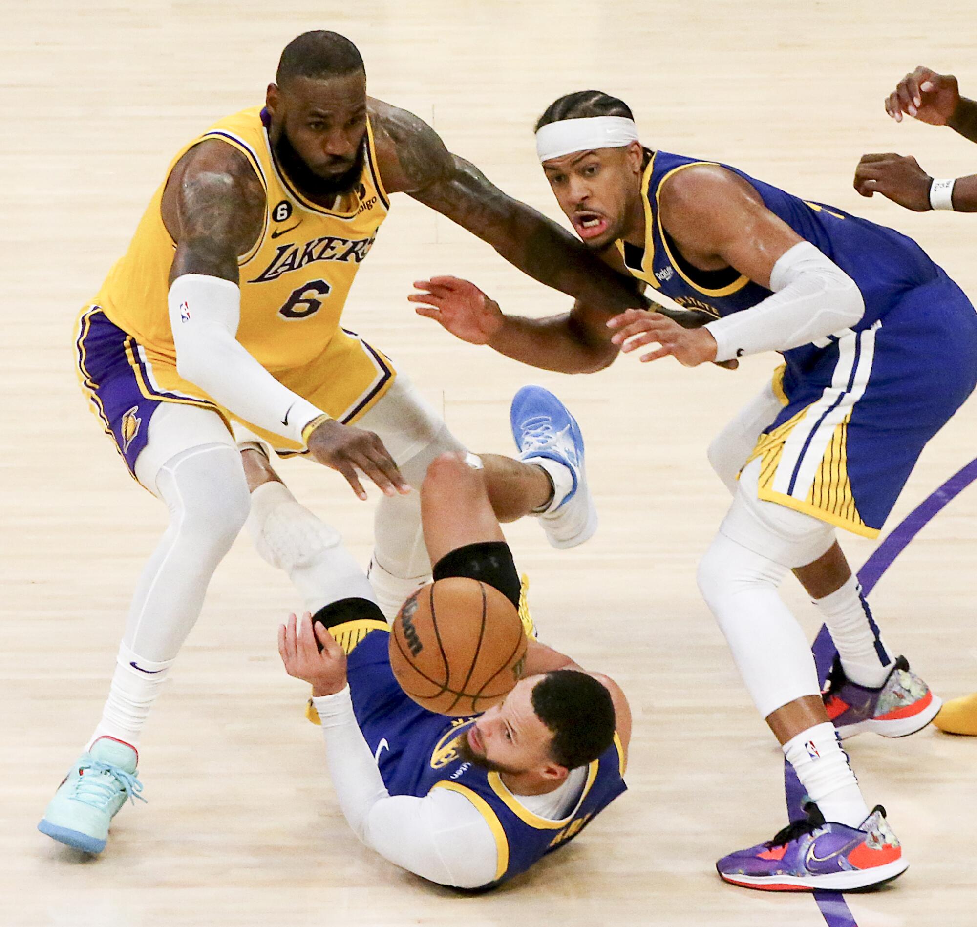 Lakers star LeBron James forces Warriors guard Stephen Curry to turn over the ball.