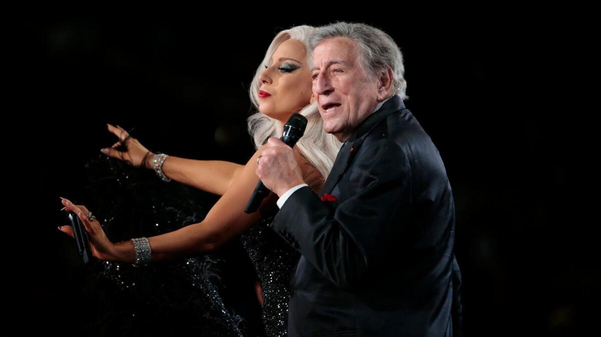 Tony Bennett sings with Lady Gaga while both wear black outfits.