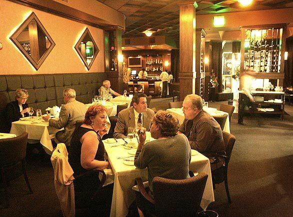 Diners enjoy the relaxed but classy atmosphere in the main dining room of Miki Zivkovics new restaurant ,Third & Olive in Burbank. The bar, where Zivkovic plans to put a grand piano, can be seen in the background.