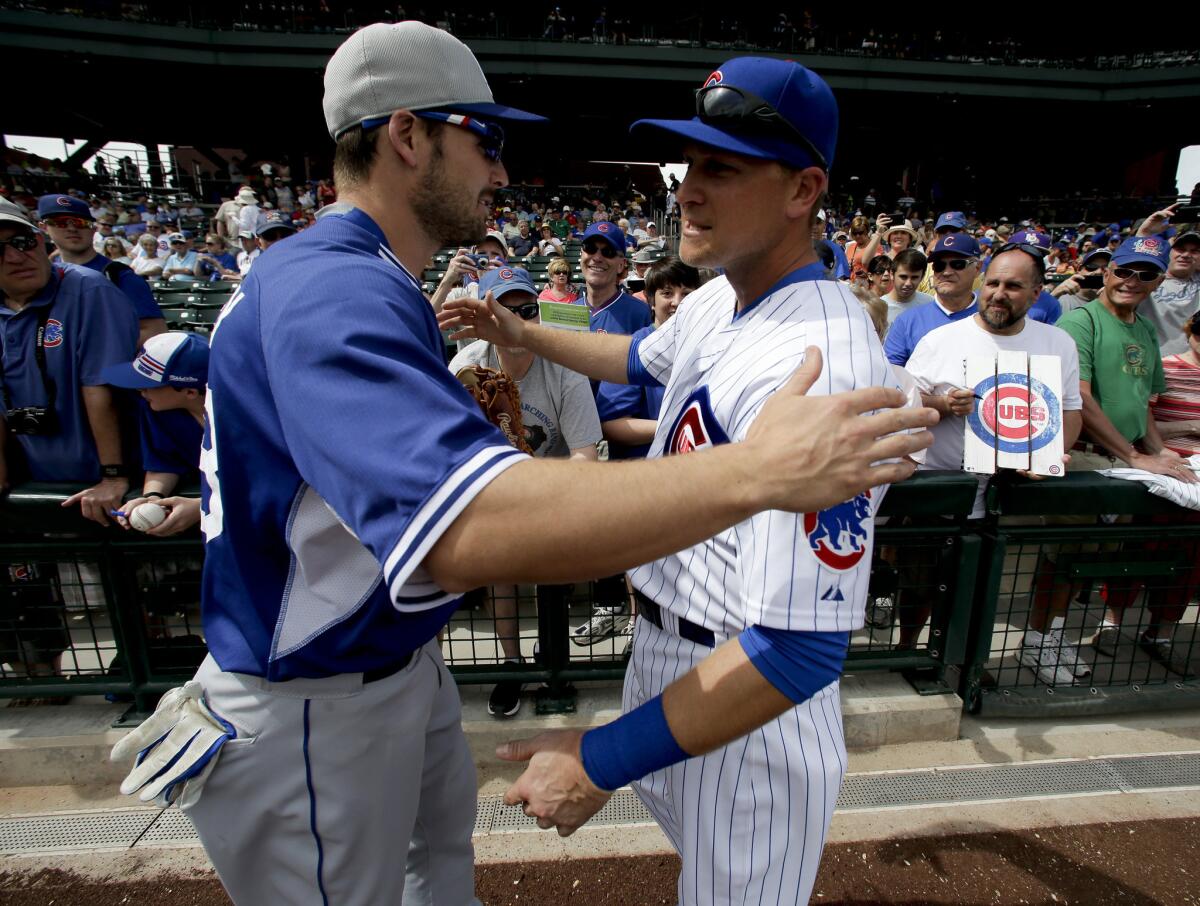 Dodgers outfielder Chris Heisey greets Chicago Cubs infielder Chris Valaika before a spring training game on March 11.