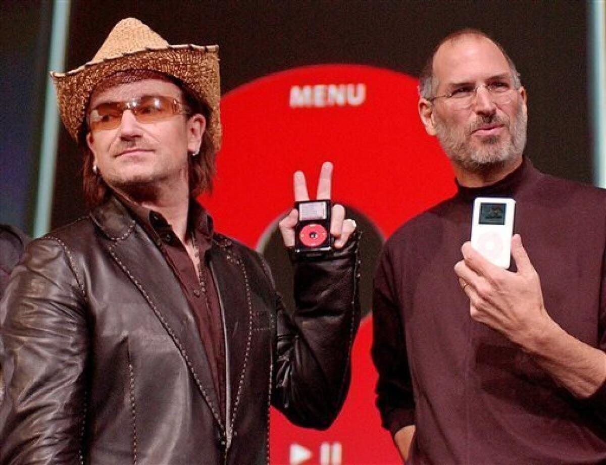 FILE - This is Tuesday, Oct. 2, 2004 file photo of Bono, left, of the band U-2, and Apple Computers Inc. Chief Executive Steve Jobs, hold up Apple iPods at an unveiling of a new branded iPod in San Jose, Calif. (AP Photo/Paul Sakuma, File)