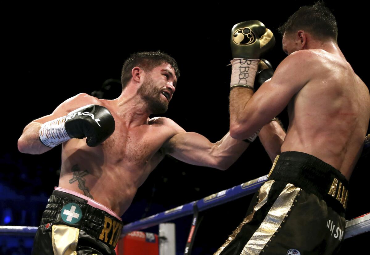 John Ryder takes a swing at Callum Smith while they fight in a boxing ring