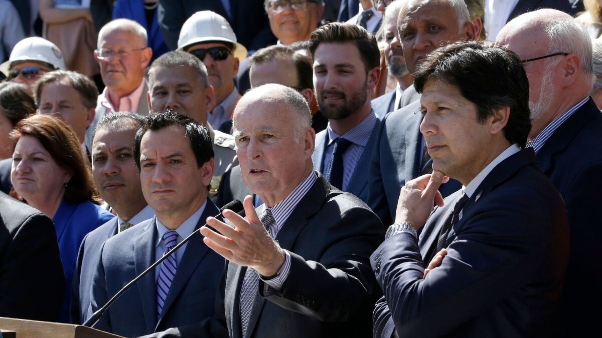 Gov. Jerry Brown answers a question last month about the $52 billion plan to fix California roads. Brown was flanked by Assembly Speaker Anthony Rendon, D-Paramount and Senate President Pro Tem Kevin de Leon, D-Los Angeles, as well as other lawmakers, and supporters of the plan.