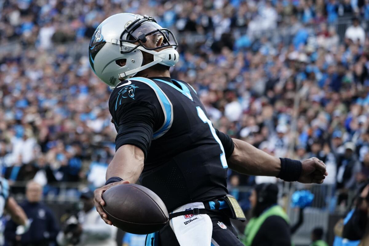 Carolina Panthers quarterback Cam Newton celebrates his touchdown pass to running back Christian McCaffrey during the second half of an NFL football game against the Washington Football Team Sunday, Nov. 21, 2021, in Charlotte, N.C. (AP Photo/Jacob Kupferman)