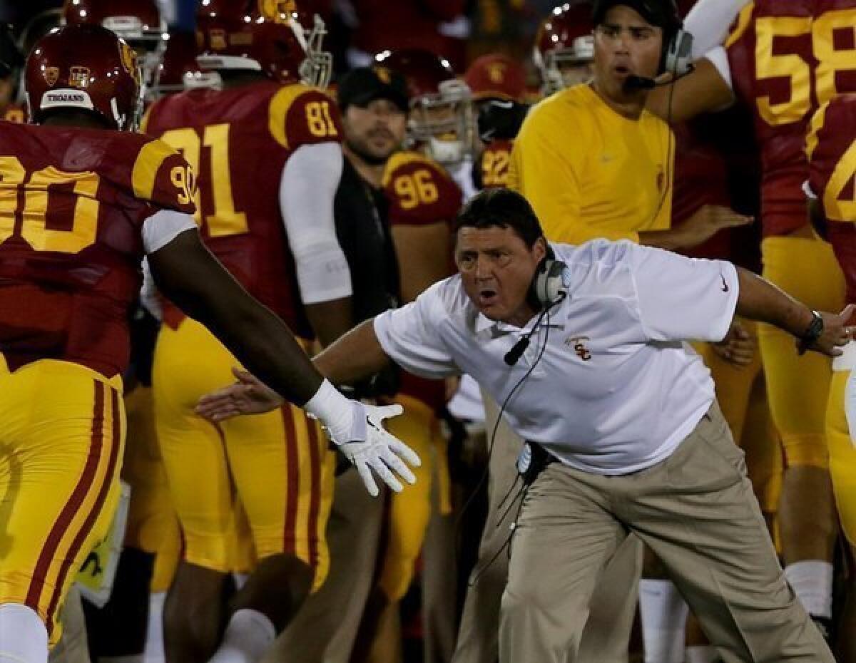 USC interim coach Ed Orgeron congratulates his team during a game against Arizona on Thursday.