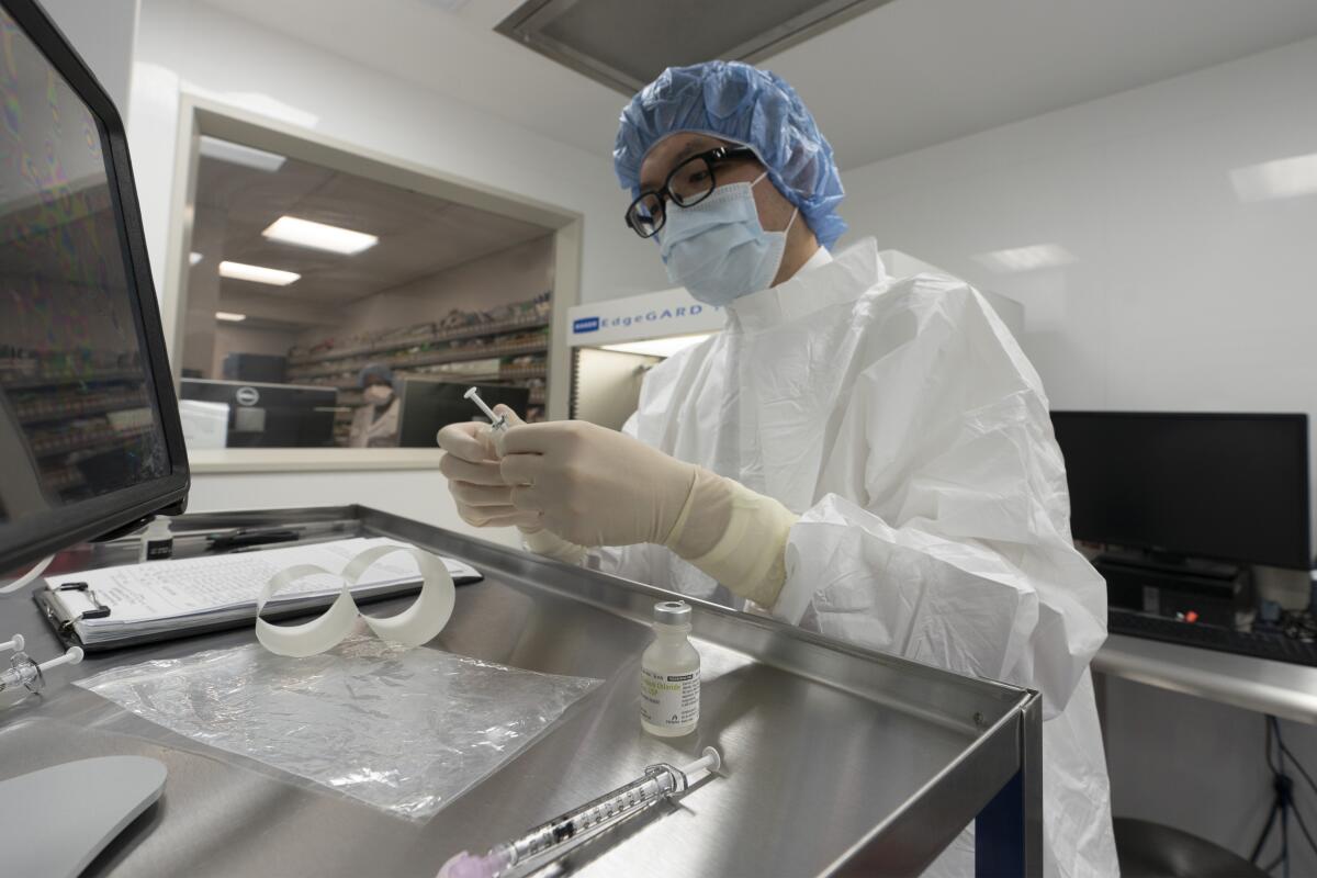 A pharmacist at Mount Sinai Queens hospital labels syringes in a clean room where doses of COVID-19 vaccines will be handled.