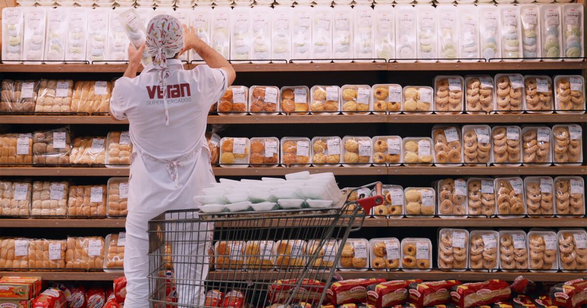 A worker stocks baked goods in the documentary "My Darling Supermarket."