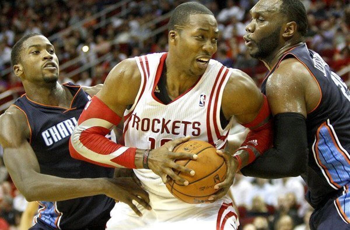 Rockets center Dwight Howard is sure to draw double teams like the one deployed by Charlotte's Michael Kidd-Gilchrist, left, and Al Jefferson.