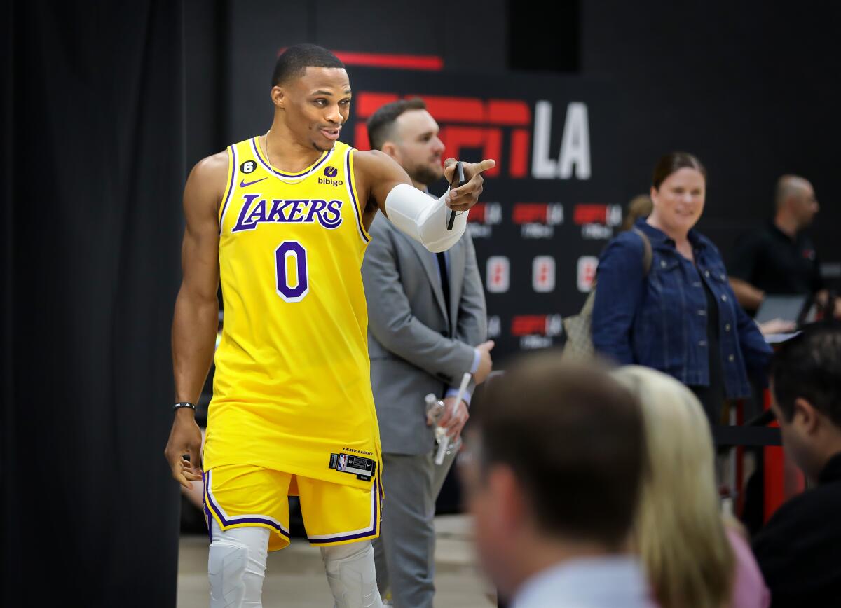 Russell Westbrook points toward someone during media day.