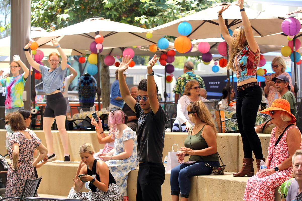 A flash mob takes over the quad area and dances around guests to the song "Celebration" during the Festival of Arts.