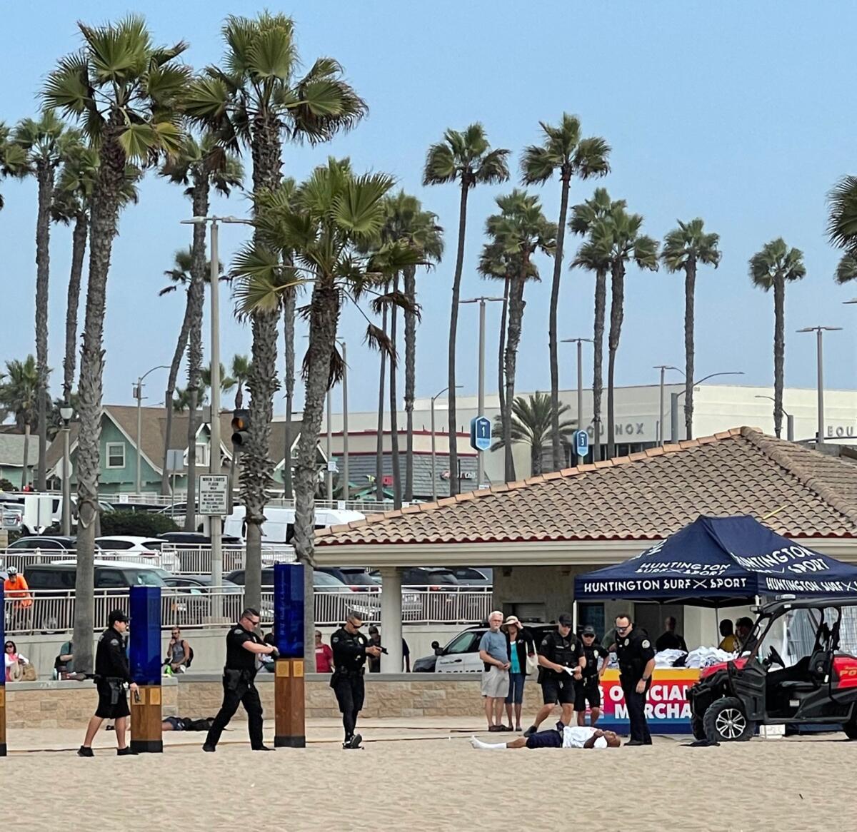 Police surround Ronnie Andrew Garcia on Saturday afternoon at Huntington City Beach.