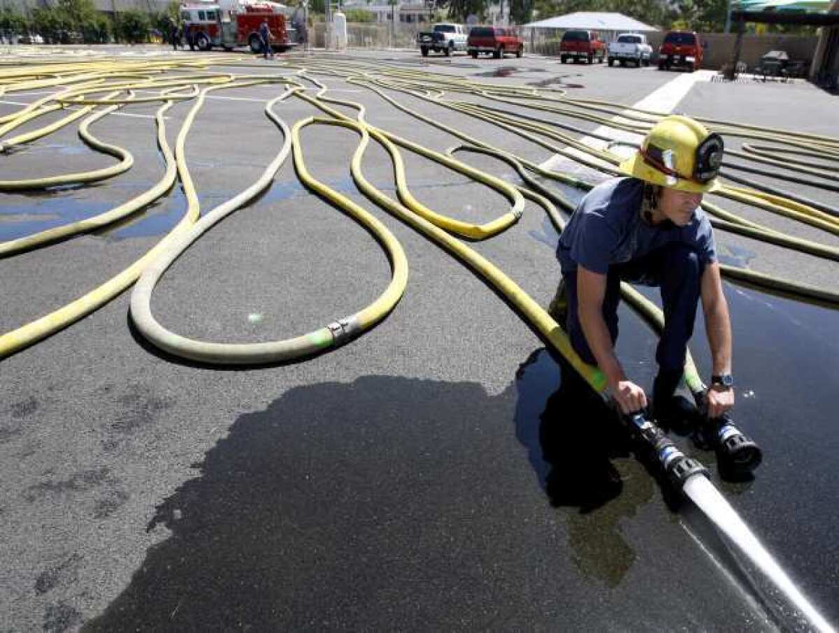 Burbank Fire Station 12 firefighter Brandon Vaughan releases trapped air from fire hoses.