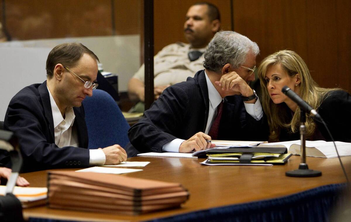 Christian K. Gerhartsreiter, left, jots down notes while two of his attorneys confer during opening statements of his murder trial. He is accused of killing John Sohus, who vanished with his wife in the spring of 1985.