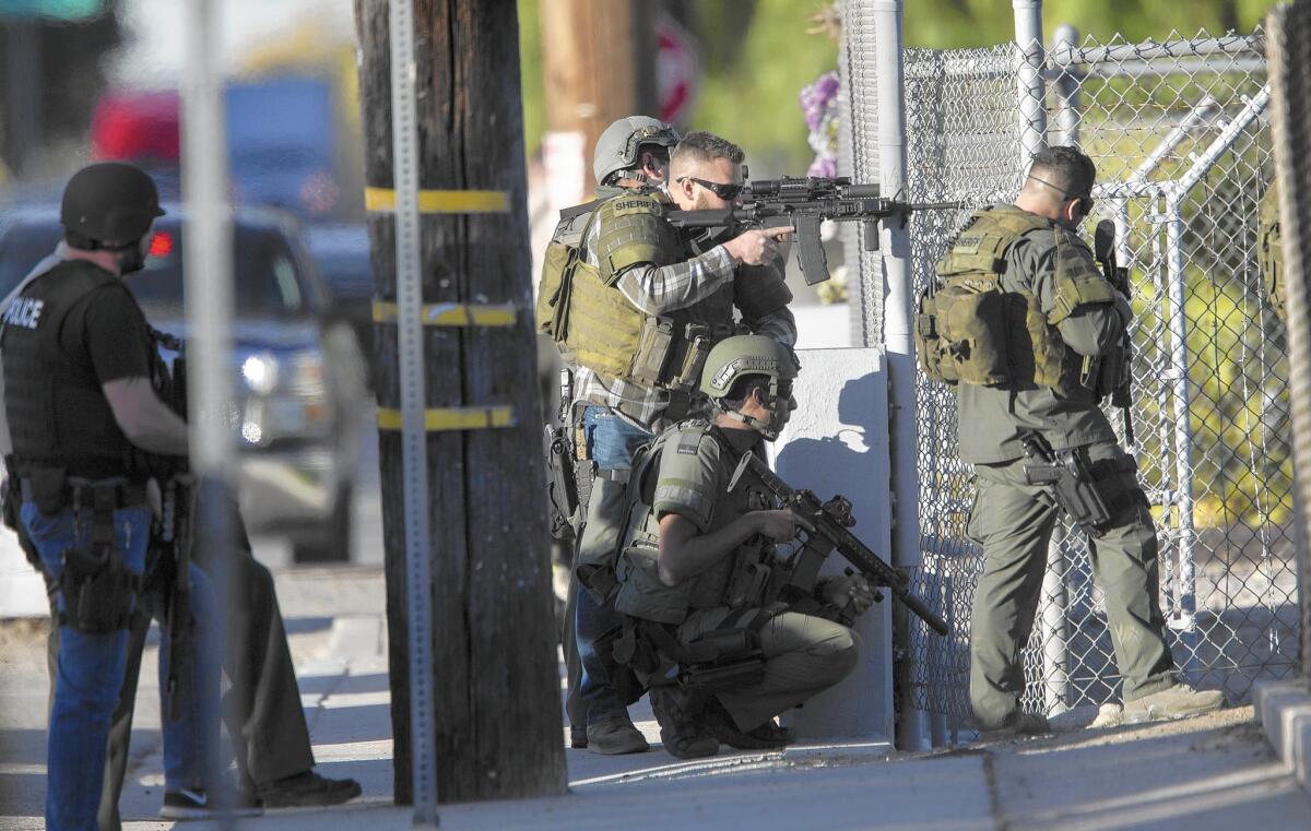 SWAT officers search near Victoria Elementary School for those involved in the attack at the Inland Regional Center in San Bernardino. Witnesses initially reported that three shooters were involved.