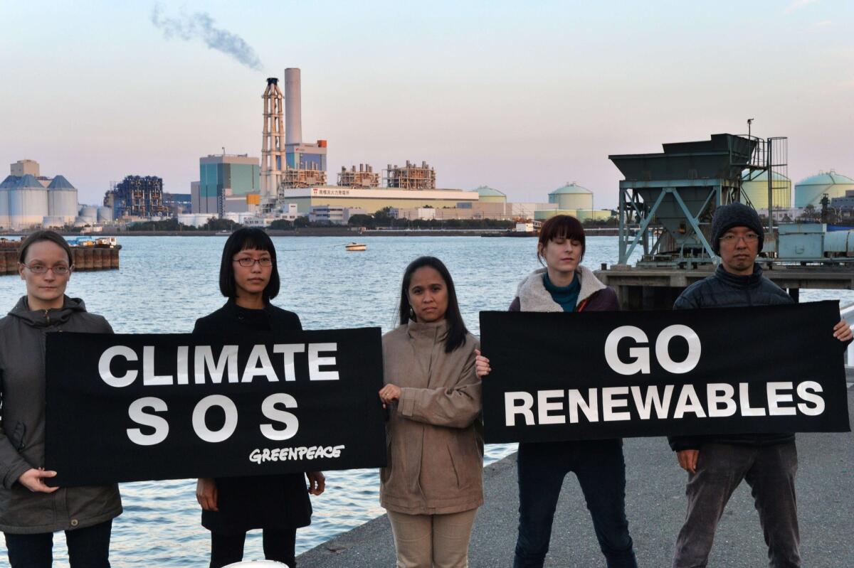 Members of environmental group Greenpeace display banners in Yokohama, suburban Tokyo to protest against global warming.