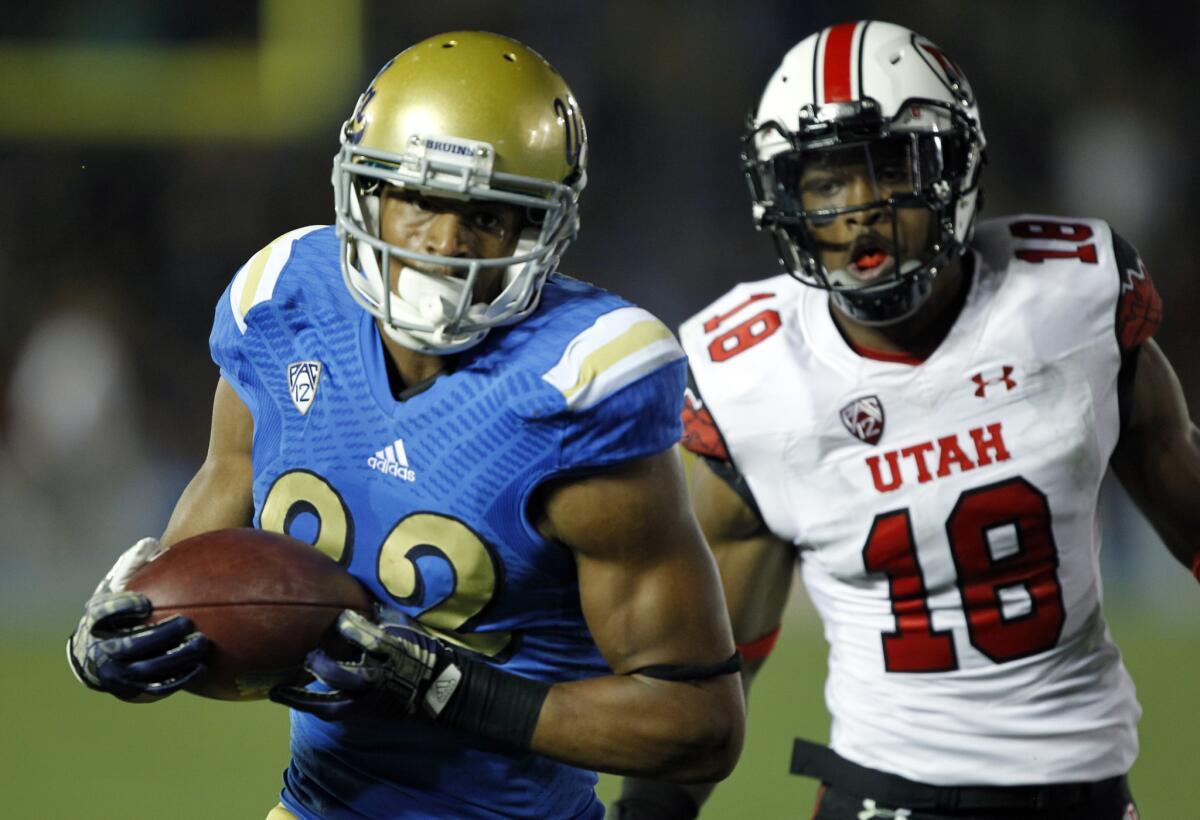 UCLA wide receiver Eldridge Massington catches a pass for a touchdown against Utah defensive back Eric Rowe during a game on Oct. 4, 2014.