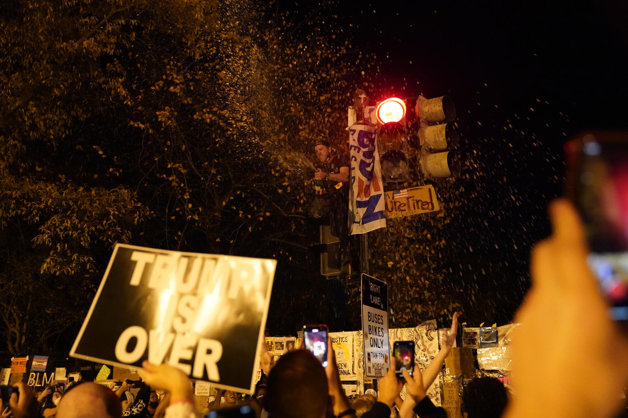 A man sprays champagne on the crowd as people celebrate near the White House