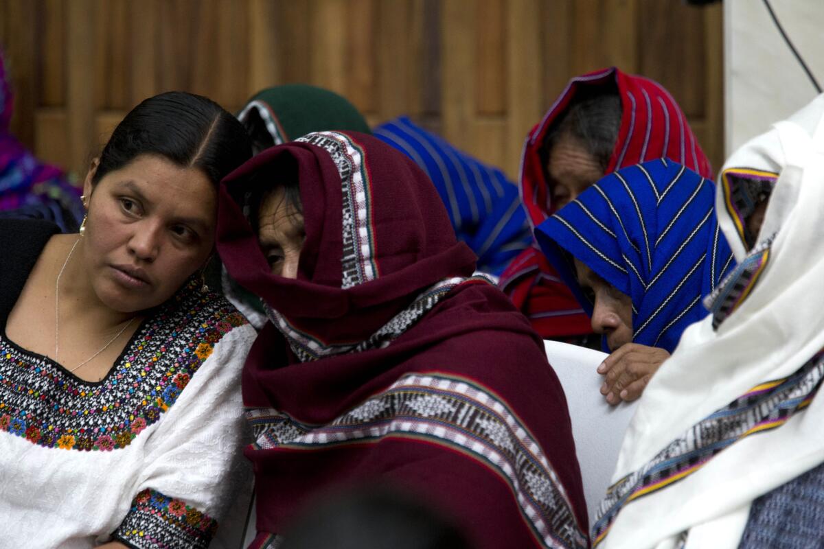 Víctimas de violencia sexual cubren sus rostros mientras escuchan a una intérprete, izquierda, en el primer día de un juicio contra un ex militar y un ex paramilitar en Guatemala. Ambos son juzgados por presunto asesinato, desaparición, violaciones sexuales y esclavitud laboral de al menos 15 mujeres durante el conflicto armado en Guatemala. (AP Photo/Moises Castillo)