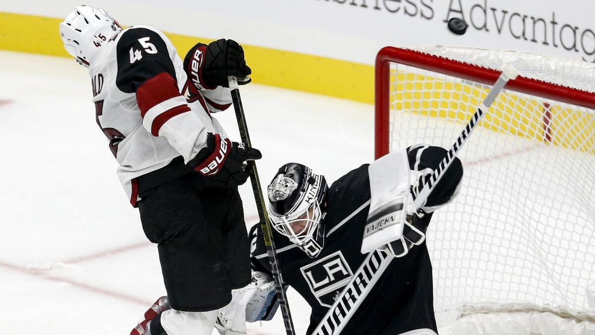 Kings goalie Cal Petersen, right, is crowded in net by Arizona's Josh Archibald during a preseason game on Sept. 18.