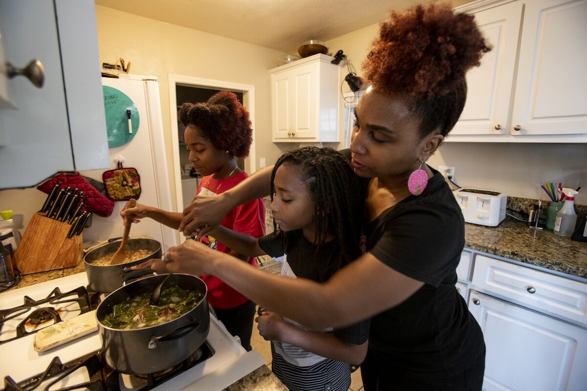A mother and her children cook black eyed peas and collard greens