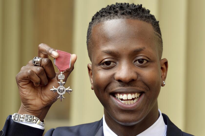 FILE - Jamal Edwards holds his Member of the British Empire (MBE) after it was awarded to him by the Prince of Wales at an Investiture Ceremony at Buckingham Palace in London on March 26, 2015. Music entrepreneur Jamal Edwards, who helped launch the careers of artists including Ed Sheeran, Jessie J and Stormzy, has died. He was 31. His mother, broadcaster Brenda Edwards, said Monday, Feb. 21, 2022 that her son died the day before after a sudden illness. She said the family was “completely devastated," and tributes poured in from across Britain's entertainment industry. (John Stillwell/PA via AP, File)
