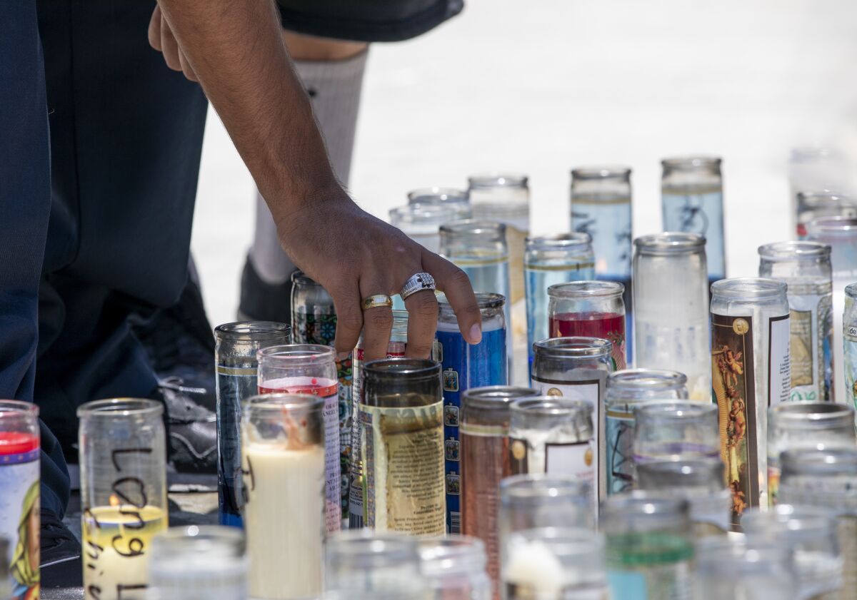 Friends arrange candles at a memorial site for Omar Marquez Jr., 15