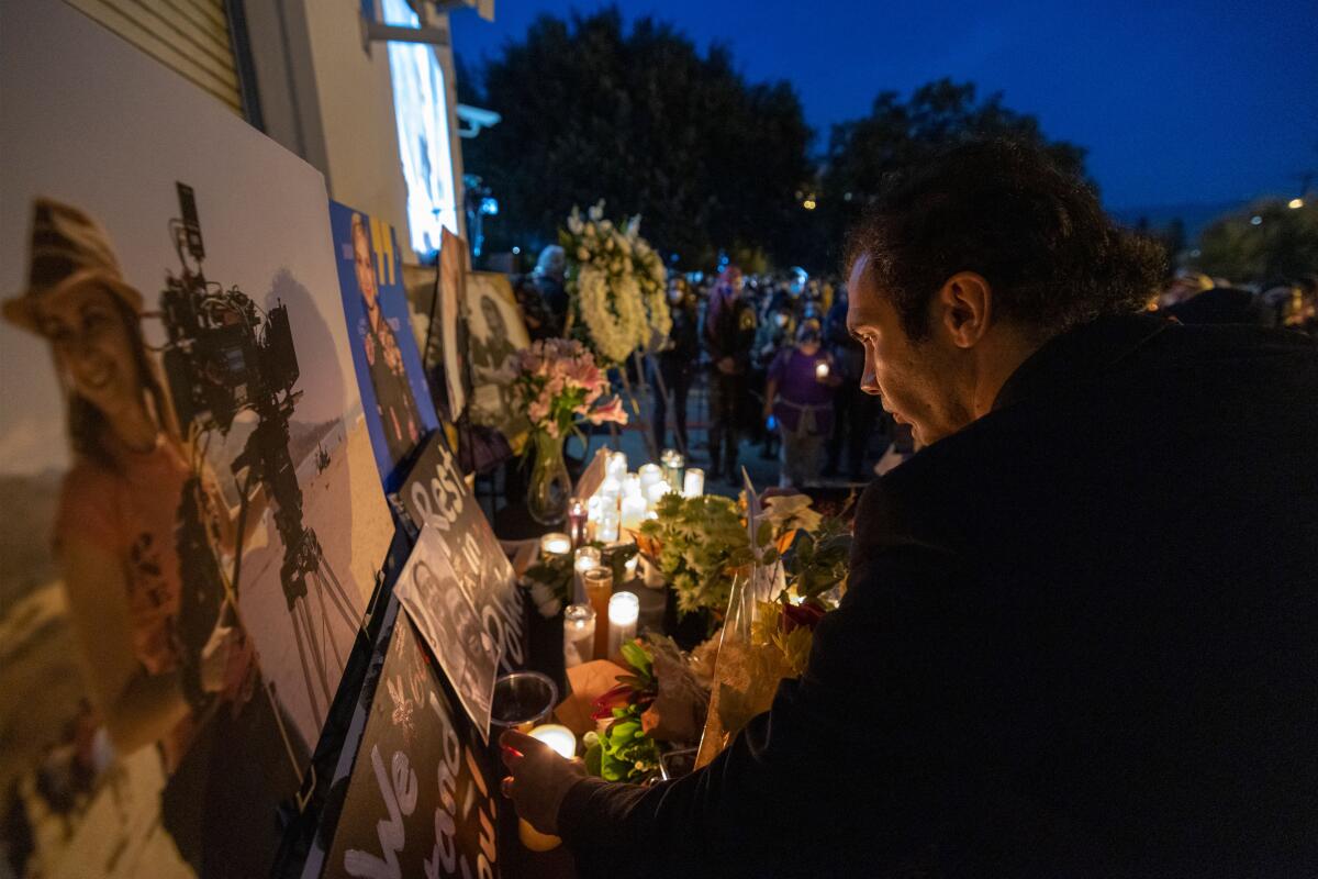A man pays his respects near a photo of Halyna Hutchins at a vigil held in the cinematographer's memory. 