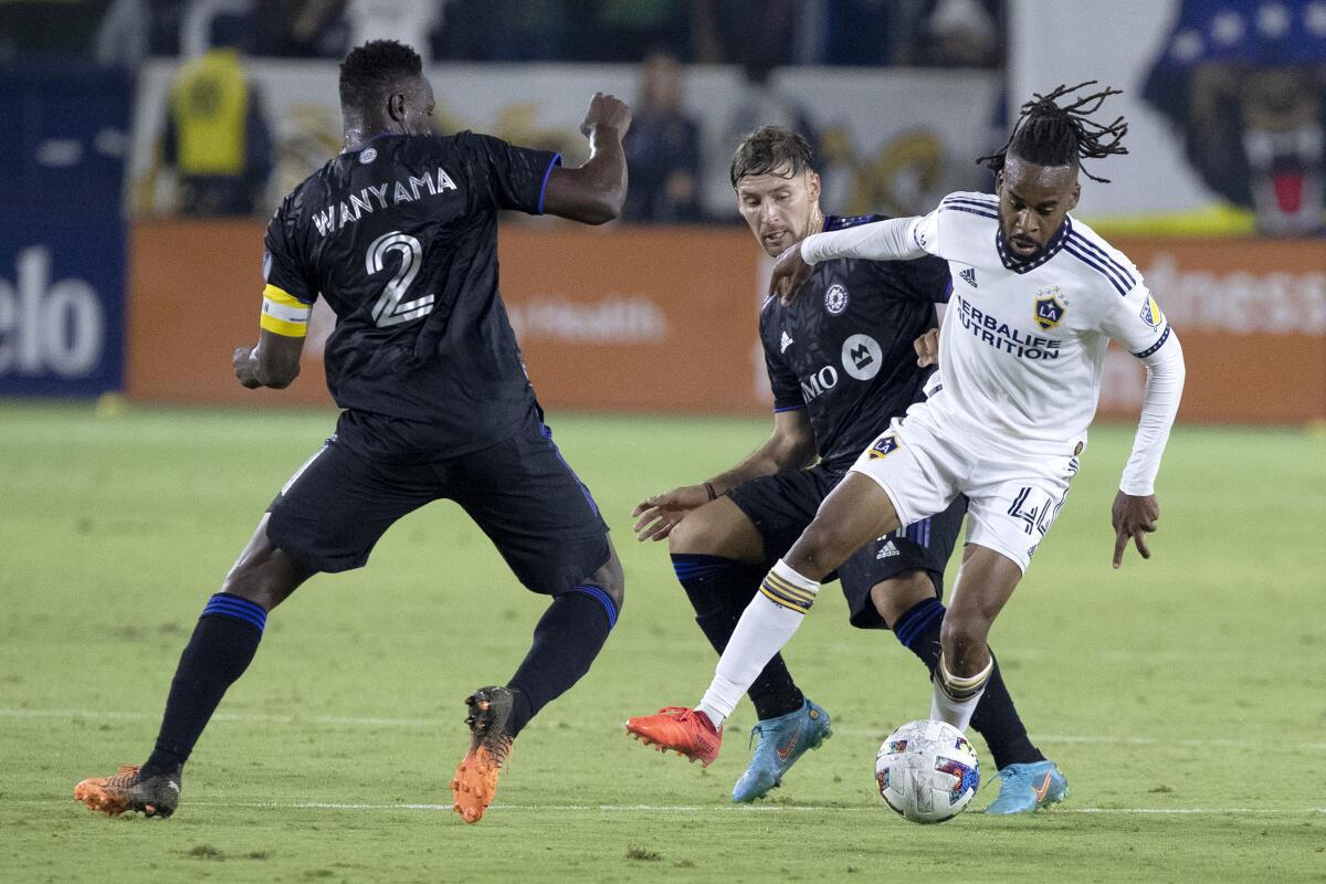 Galaxy forward Raheem Edwards controls the ball against CF Montreal midfielder Victor Wanyama and midfielder Matko Miljevic 