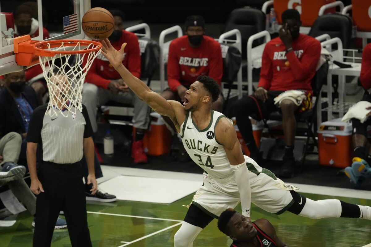 The Bucks' Giannis Antetokounmpo leaps over the Hawks' Clint Capela for a shot attempt in Game 2 on June 25, 2021.