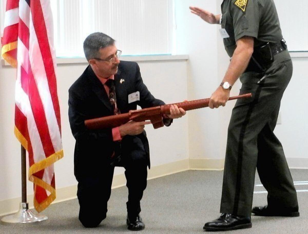 John L. Fernatt, left, poses as a gunman, and Sgt. Michael D. Lynch of the West Virginia State Police demonstrates how a person could grab the muzzle of the weapon. The two, along with Chuck S. Mozingo Jr., have teamed up to show West Virginians how to protect themselves in such situations.