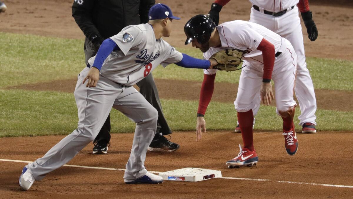 Dodgers' Manny Machado tags out Red Sox's Ian Kinsler at third base in the second inning of Game 2 of the World Series at Fenway Park on Wednesday in Boston.