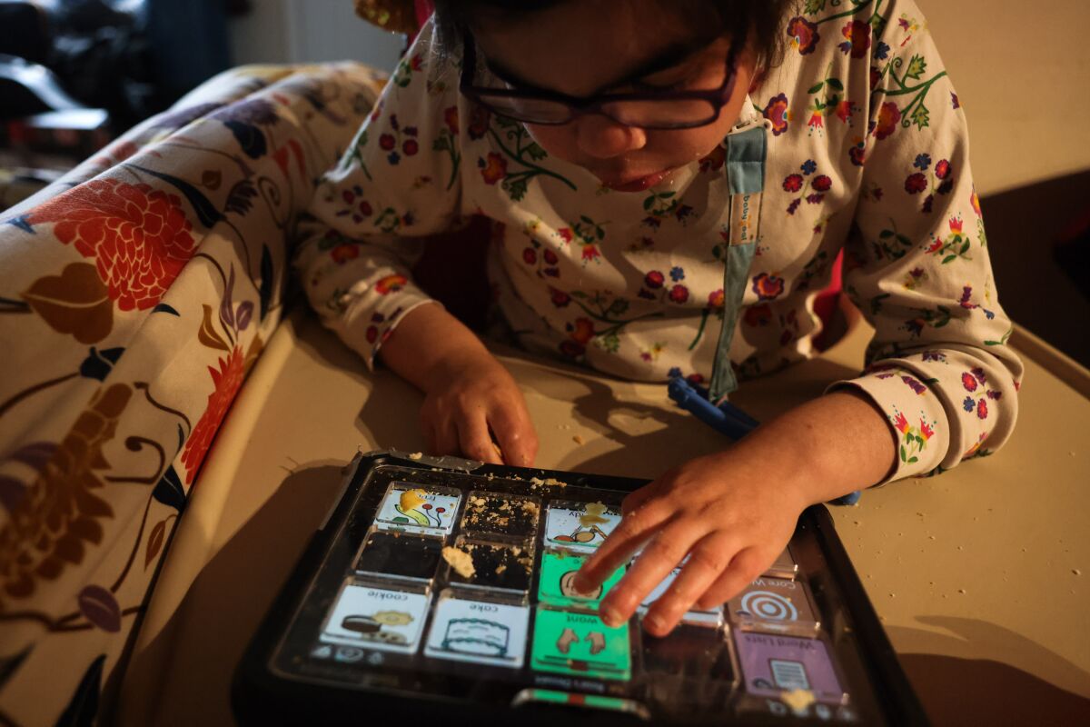 A girl with special needs uses a program on her tablet to help her communicate.