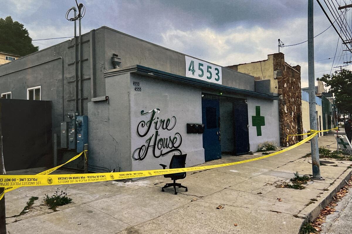 A gray building signed Fire House is blocked off by police tape.