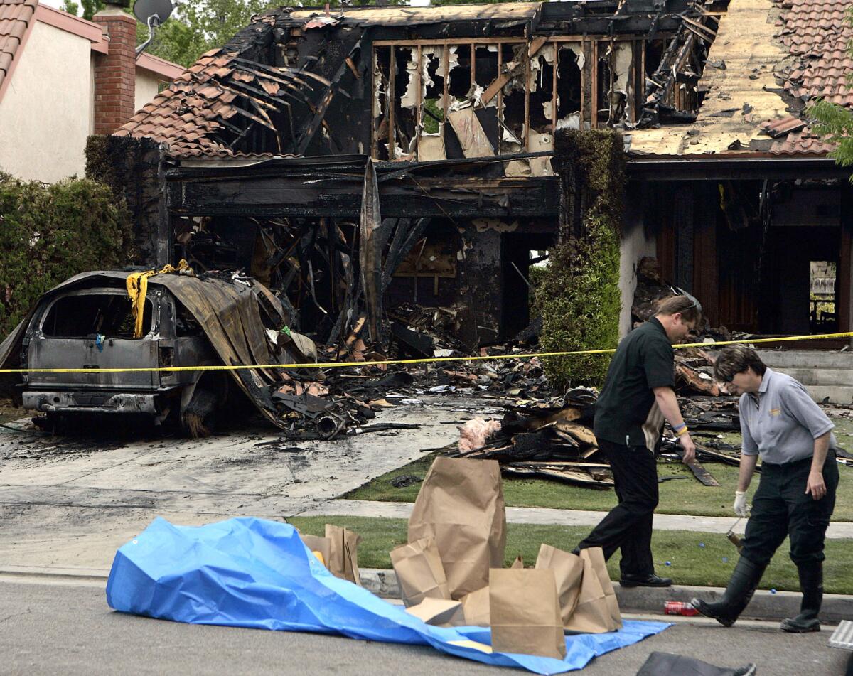 Fire investigators search for clues after a fire was set to an Anaheim Hills home where a man, woman and child were attacked.