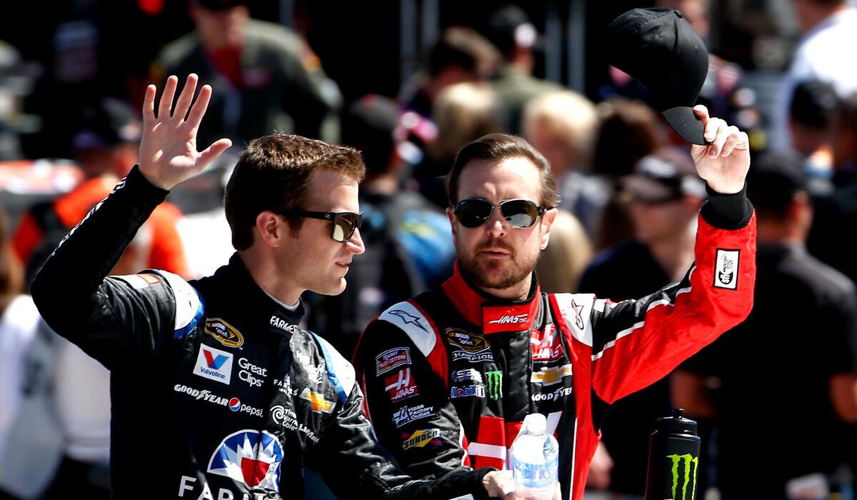 Kasey Kahne, left, and Kurt Busch take part in pre-race ceremonies for the NASCAR Sprint Cup Series CampingWorld.com 500 at Phoenix International Raceway on Sunday.