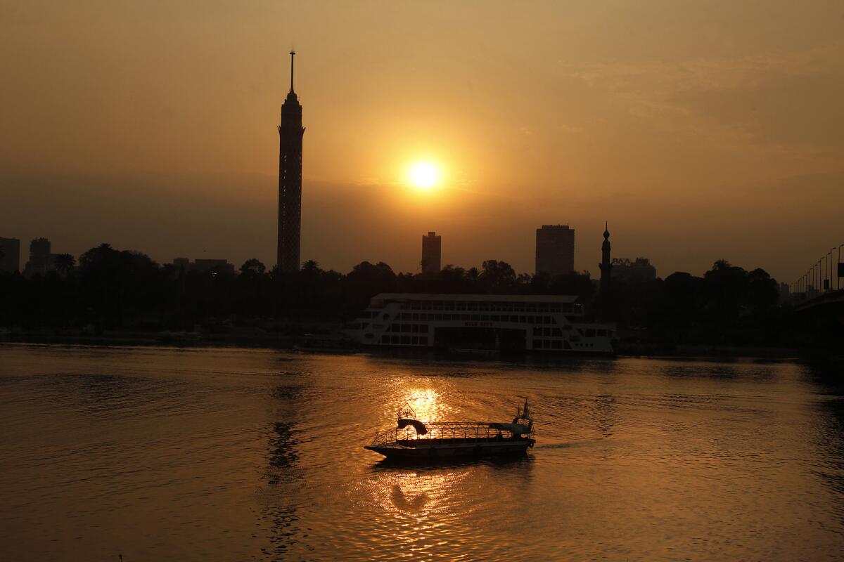 A boat cruises the Nile River at sunset.