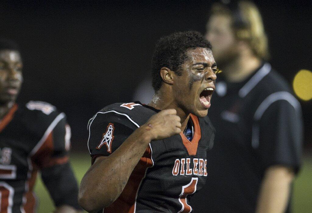 Huntington Beach's Kai Ross gets his team pumped up during a game against Newport Harbor on Friday.