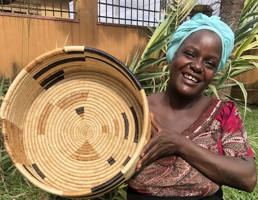 An African artisan shows a handwoven basket that she and others make as part of a sales coop with U.S. buyers.