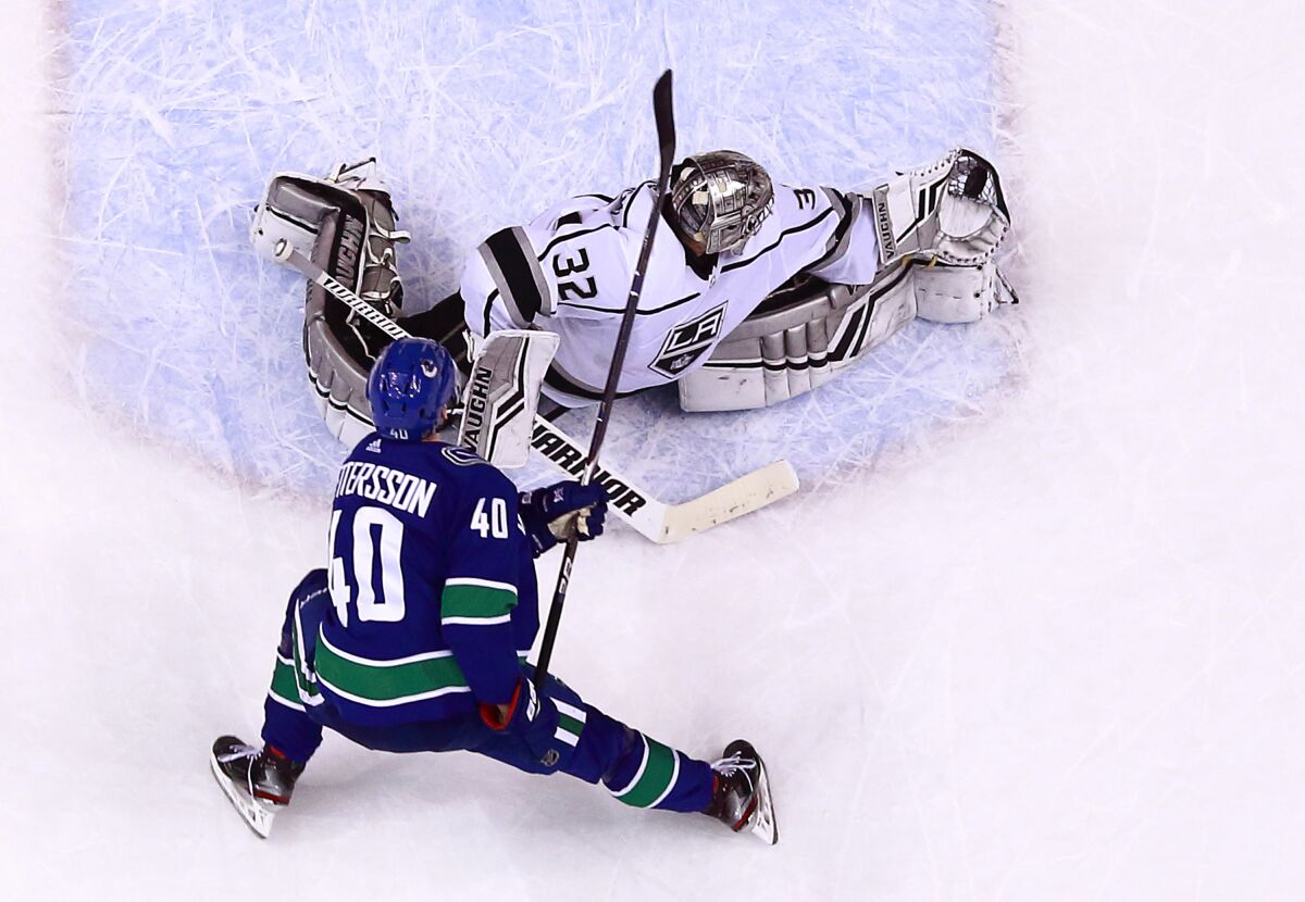 Kings goaltender Jonathan Quick makes a glove save off the shot by Vancouver's Elias Pettersson.